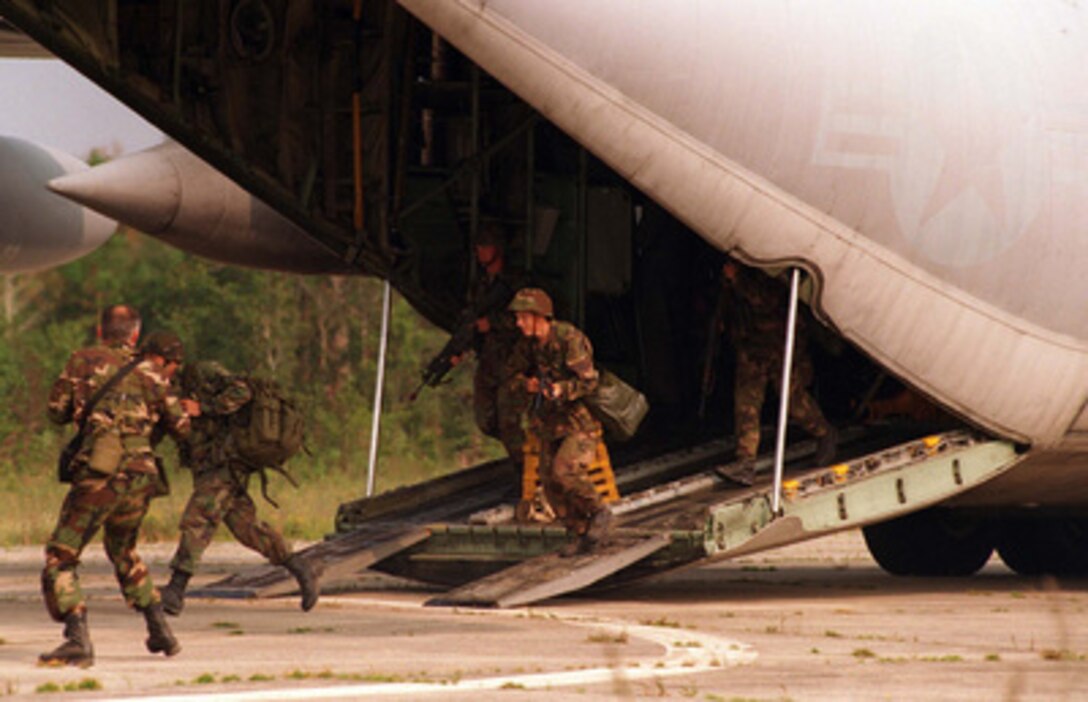 Members of Company 4 run off a U.S. Air Force C-130 Hercules at Davis Airfield during an Airfield Security, Convoy Operations, and Humanitarian Assistance Final Training Exercise at Camp Lejeune, N.C., on Aug. 24, 1996 as part of Cooperative Osprey '96. Cooperative Osprey '96 is a NATO sponsored exercise as part of the alliance's Partnership for Peace program. The aim of the exercise is to develop interoperability among the participating forces through practice in combined peacekeeping and humanitarian operations. Three NATO countries and 16 Partnership for Peace nations are taking part in the field training exercise. 