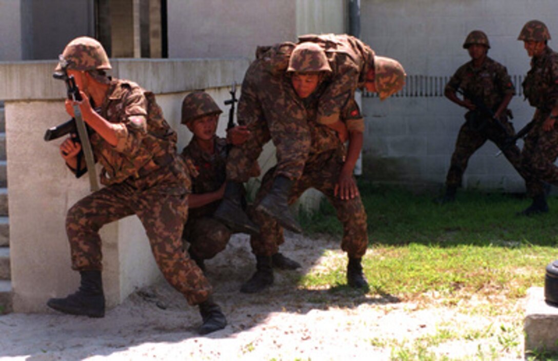 Soldiers from Kyrgystan carry a simulated wounded soldier to safety while training at the Military Operations in Urban Terrain facility at Camp Lejeune, N.C., on Aug. 21, 1996 as part of Cooperative Osprey '96. Cooperative Osprey '96 is a NATO sponsored exercise as part of the alliance's Partnership for Peace program. The aim of the exercise is to develop interoperability among the participating forces through practice in combined peacekeeping and humanitarian operations. Three NATO countries and 16 Partnership for Peace nations are taking part in the field training exercise. 