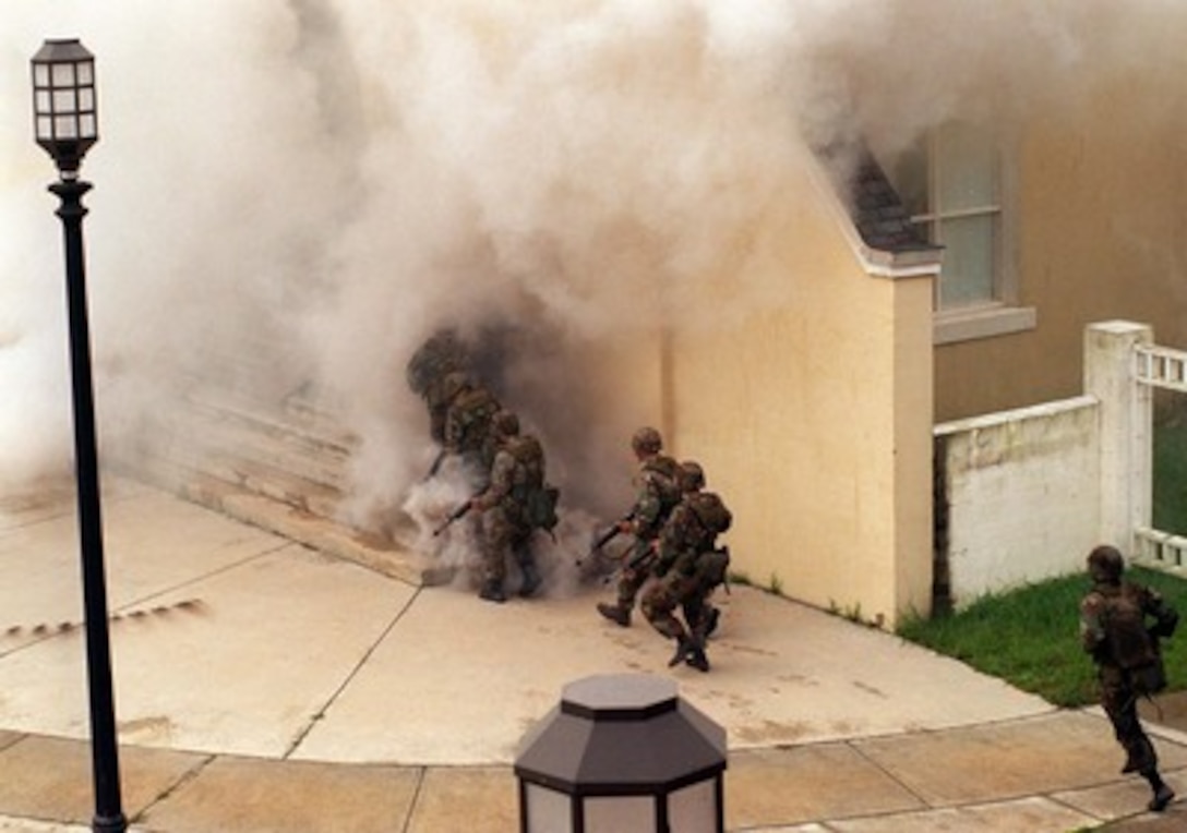 U.S. Marines clear a building of hostile civilians during a final training exercise in the Military Operations in Urban Terrain facility at Camp Lejeune, N.C., on Aug. 26, 1996, as part of Cooperative Osprey '96. Cooperative Osprey '96 is a NATO sponsored exercise as part of the alliance's Partnership for Peace program. The aim of the exercise is to develop interoperability among the participating forces through practice in combined peacekeeping and humanitarian operations. Three NATO countries and 16 Partnership for Peace nations are taking part in the field training exercise. 