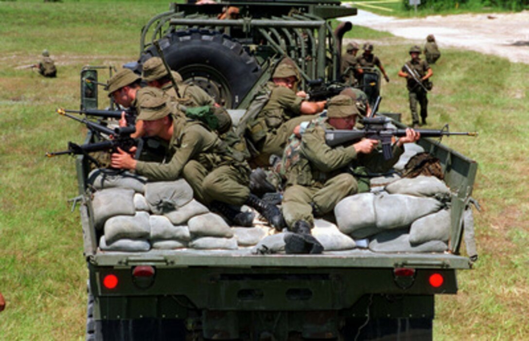 Canadian soldiers practice convoy operations during a Situational Training Exercise at Camp Lejeune, N.C., on Aug. 21, 1996, as part of Cooperative Osprey '96. Sand bags are laid in the bed of the truck to protect the soldiers from mine blasts. Cooperative Osprey '96 is a NATO sponsored exercise as part of the alliance's Partnership for Peace program. The aim of the exercise is to develop interoperability among the participating forces through practice in combined peacekeeping and humanitarian operations. Three NATO countries and 16 Partnership for Peace nations are taking part in the field training exercise. 