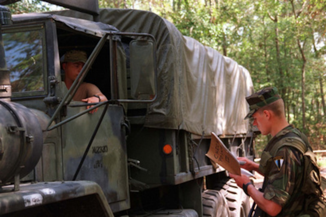 An Estonian soldier checks the identification of a truck driver attempting to pass through his road block during a Check Point Operations/ Weapons Disarmament Situational Training Exercise at Camp Lejeune, N.C., on Aug. 21, 1996 as part of Cooperative Osprey '96. Cooperative Osprey '96 is a NATO sponsored exercise as part of the alliance's Partnership for Peace program. The aim of the exercise is to develop interoperability among the participating forces through practice in combined peacekeeping and humanitarian operations. Three NATO countries and 16 Partnership for Peace nations are taking part in the field training exercise. 