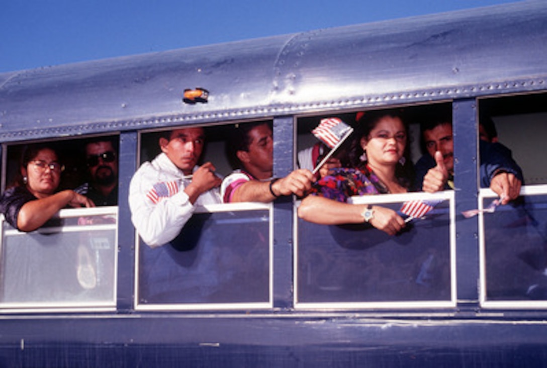 Cuban migrants wait on a bus prior to boarding a plane which will take them from Naval Station Guantanamo Bay, Cuba, to Homestead Air Force Base, Fla., on Jan. 31, 1996. The Cubans are the last to leave the migrant processing center at Guantanamo Bay. A military, Joint Task Force 160 was originally established on May 18, 1994, to provide humanitarian assistance to Haitians escaping political strife. A wave of Cuban migrants followed in August of 1994. All Haitians and Cubans recovered at sea were transported to Guantanamo Bay. At its height in early October 1994, the tent city at Guantanamo Bay sheltered more than 46,000 Haitian and Cuban migrants. 