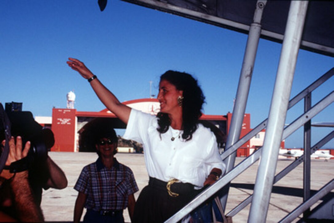 The last Cuban migrant, Margarita Uria Sanchez waves as she boards a plane which will take her and other Cubans from Naval Station Guantanamo Bay, Cuba, to Homestead Air Force Base, Fla., on Jan. 31, 1996. The Cubans are the last to leave the migrant processing center at Guantanamo Bay. A military, Joint Task Force 160 was originally established on May 18, 1994, to provide humanitarian assistance to Haitians escaping political strife. A wave of Cuban migrants followed in August of that same year. All Haitians and Cubans recovered at sea were transported to Guantanamo Bay. At its height in early October 1994, the tent city at Guantanamo Bay sheltered more than 46,000 Haitian and Cuban migrants. 