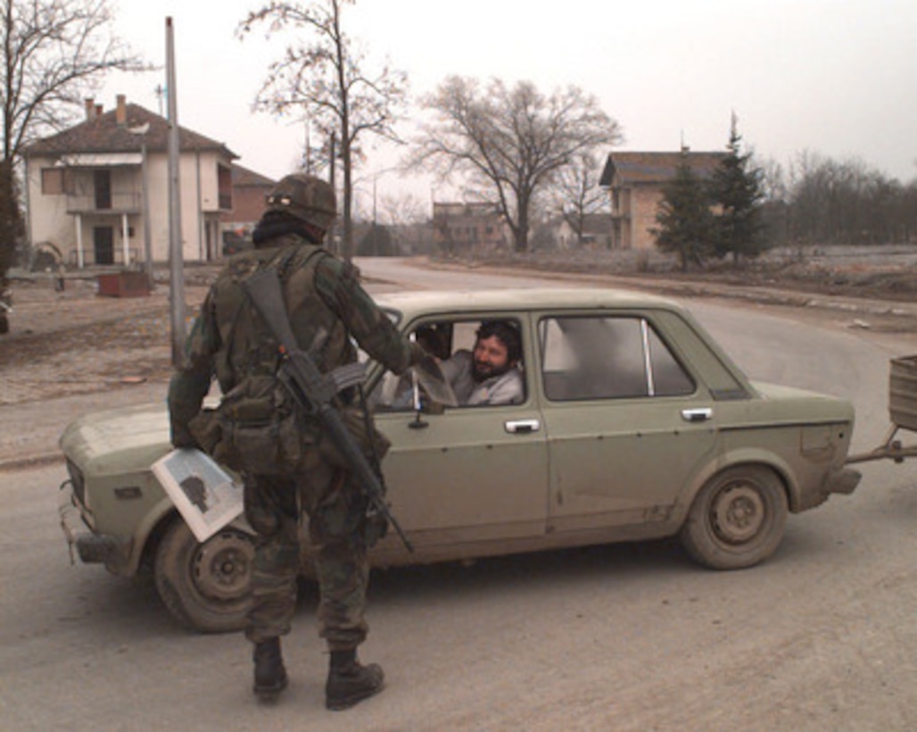 A U.S. Army soldier from the 9th Psychological Operations Battalion distributes a U.S. faction newspaper to a passing driver in the town of Odzak, Bosnia and Herzegovina, on Jan. 19, 1996. The newspaper is designed to inform the town's people about the NATO Implementation Force (IFOR) and Operation Joint Endeavor. The 9th Psychological Operations Battalion is deployed from Fort Bragg, N.C. 