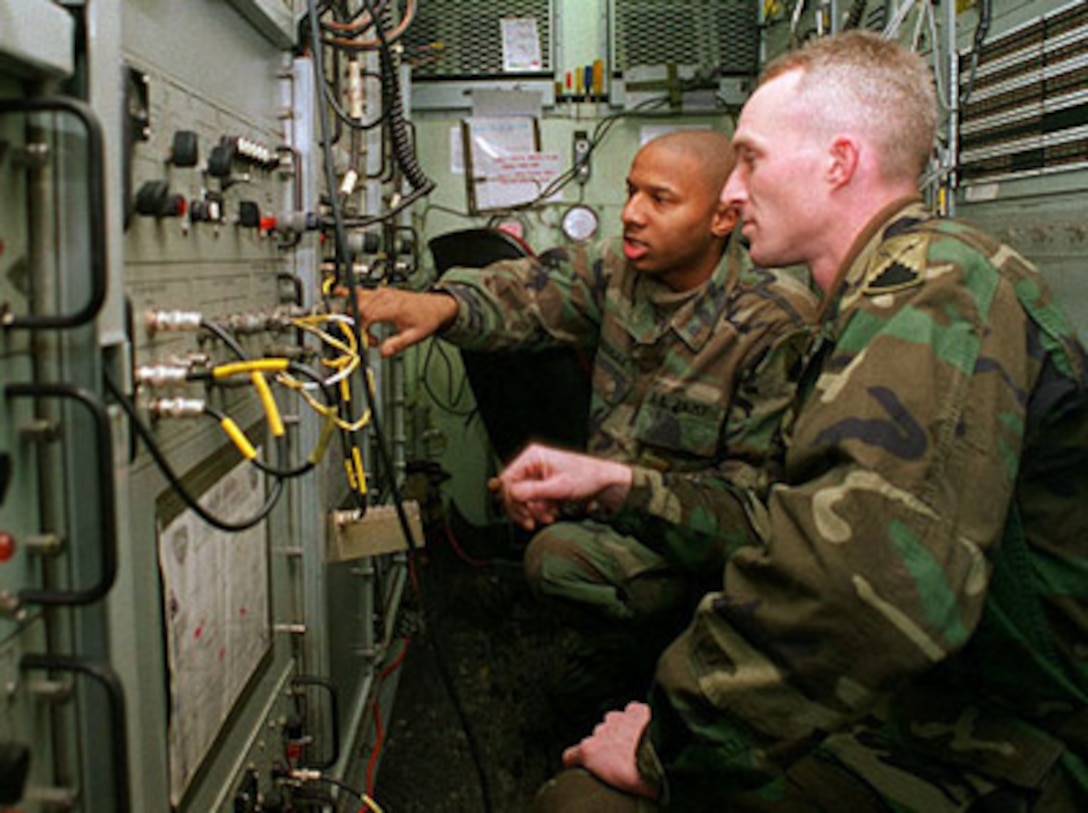 Two U.S. Army soldiers from the 44th Signal Battalion, 58th Signal Company, work in a AN/TSC-85B satellite communications terminal van near Kaposvar, Hungary, during Operation Joint Endeavor on Jan. 31, 1996. U.S. troops are deployed to Hungary to support the NATO Implementation Force (IFOR) in Bosnia and Herzegovina. 