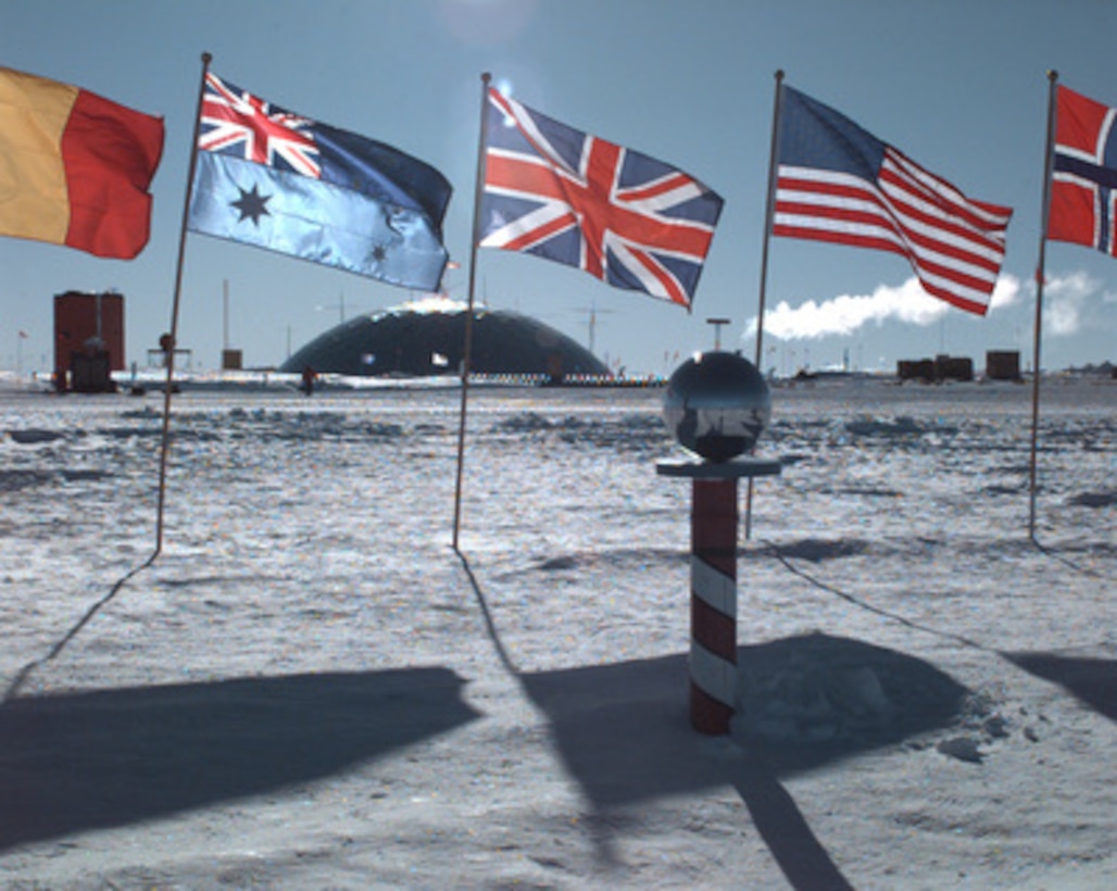 The famous dome of Antarctica's Amundsen-Scott South Pole Station shimmers in the summer sunlight on Jan. 20, 1996. The flags of 13 nations which have officially adopted the Antarctic Treaty fly at the South Pole and represent the unprecedented international cooperation among the world community on the continent. This year 27 carefully selected workers and scientists will "winter over" by spending six months in total darkness in and around the station, sometimes braving temperatures which can fall to minus 100 degrees Fahrenheit, not including wind chill. Between October and February, the remote site at "the ends of the Earth" is reached by LC-130 Hercules ski-equipped aircraft flown by specially trained U.S. Navy and Air National Guard flight crews. 