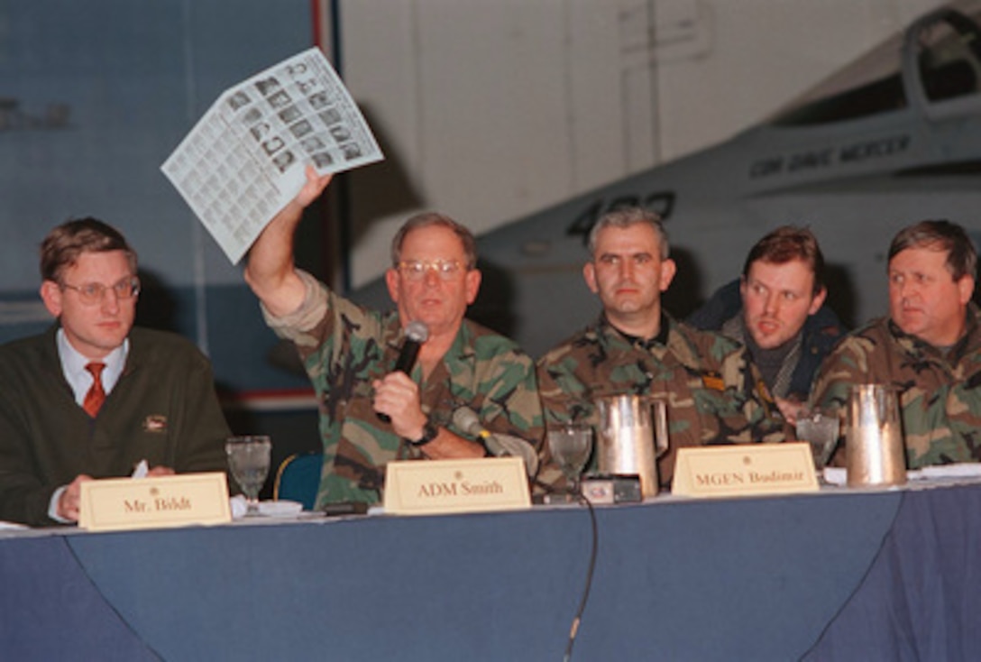 NATO Commander Adm. Leighton W. Smith Jr. displays a poster of alleged war criminals during a press conference held on board the aircraft carrier USS George Washington (CVN 73) on Jan. 19, 1996, as the ship steams in the Adriatic Sea. The flyer includes photos, names and descriptions of alleged war criminals indicted by the International Criminal Tribunal for the former Yugoslavia. The press conference was held in conjunction with the first in a series of Joint Military Commission meetings between all of the former warring factions in Bosnia and Herzegovina. The George Washington Battle group continues to operate in the Adriatic Sea in support of the NATO Implementation Force (IFOR) in Operation Joint Endeavor. 