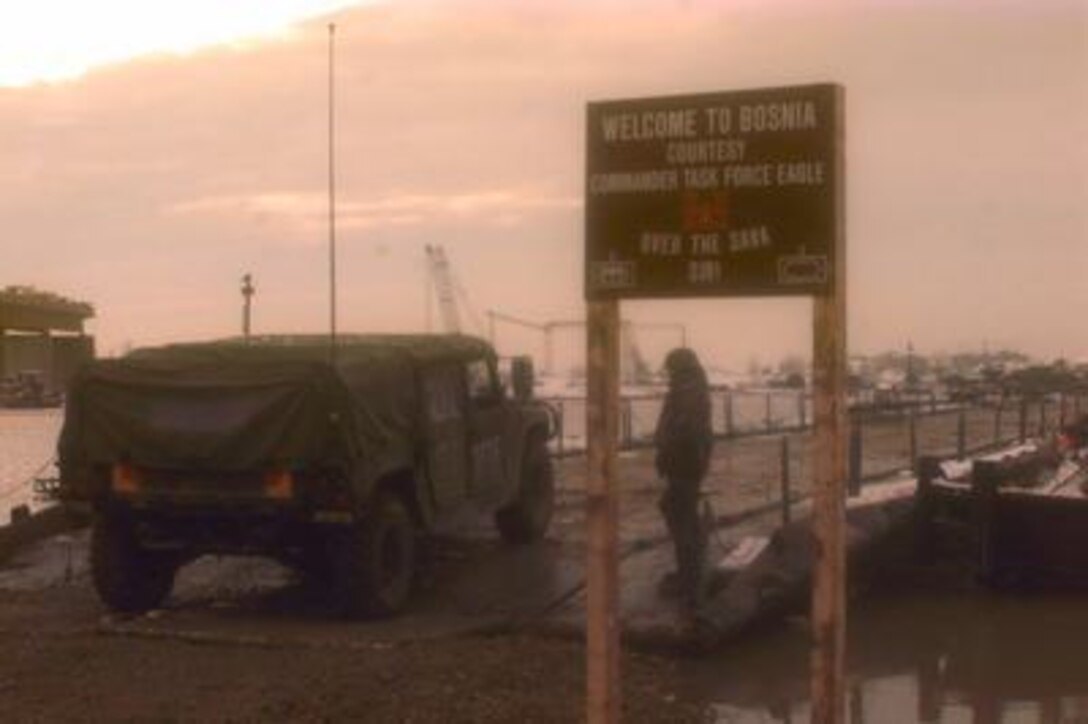 A U.S. Army Humvee drives onto the U.S. Army bridge over the Sava River from Zupania, Croatia, into Bosnia and Herzegovina on Dec. 31, 1995. U.S. Army engineers overcame freezing temperatures, unusual flooding, and other logistical challenges to build the 2,033 foot long bridge, which is longer than the Brooklyn Bridge. The bridge has become one of the primary routes for the NATO Implementation Force (IFOR) deployment into Bosnia and Herzegovina for Operation Joint Endeavor. 
