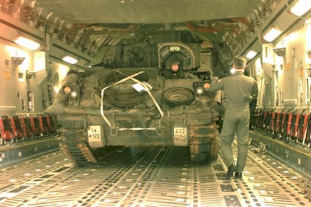 U.S. Air Force Senior Airman Brian Williams directs a U.S. Army Bradley Fighting Vehicle as it is backed into a C-17 Globemaster III at Rhein Main Air Base, Germany, on Jan. 4, 1996. The Bradley and its crew will be flown to Bosnia and Herzegovina for Operation Joint Endeavor as part of the NATO Implementation Force (IFOR). The Bradley is from the 4th Battalion, 12th Infantry Regiment, Baumholder, Germany. Williams and the Globemaster are deployed from the 17th Airlift Squadron, Charleston Air Force Base, S.C. 