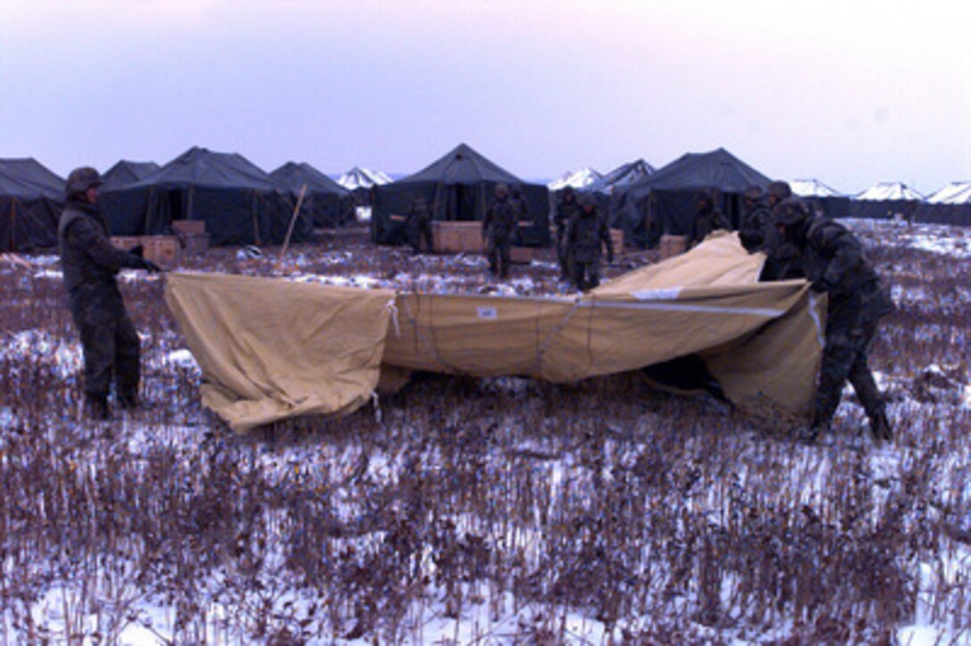 U.S. Navy Seabees erect a tent in a field outside Zupanja, Croatia, on Jan. 4, 1996. The Seabees are in to Zupanja as part of the NATO Enabling Force of Operation Joint Endeavor. Enabling forces are moving into the Croatia, Bosnia and Herzegovina, and Slovenia theaters of operation to prepare entry points for the main Implementation Force (IFOR). The Seabees, deployed from Naval Mobile Construction Battalion 133, Gulfport, Miss., will construct housing facilities for 2,500 U.S. transient troops. 