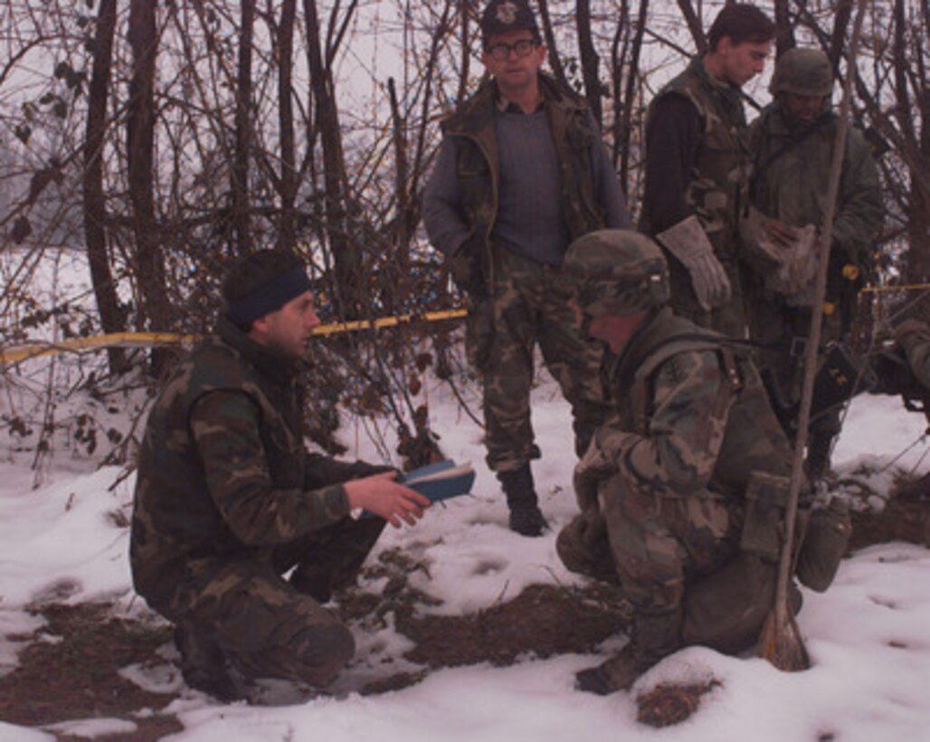 A Croatian (left) soldier and a U.S. Army soldier (right) discuss the location of mine fields near Dubrave, Bosnia and Herzegovina, on Jan. 9, 1996. The U.S. Army soldiers, deployed as part of the NATO Implementation Force (IFOR) in Operation Joint Endeavor, will mark the location of the mine fields with help of the Croatians. The soldiers are from B Company, 16th Engineer Battalion, 130th Brigade of Bamberg, Germany. 