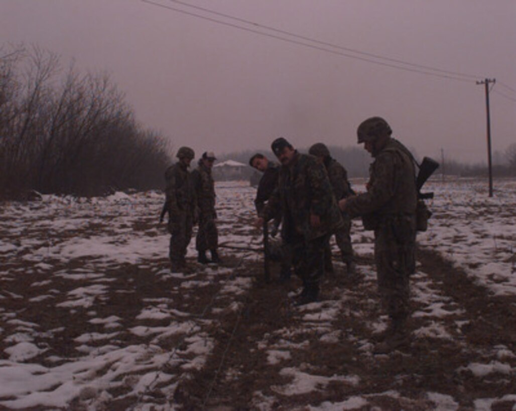 Croatian soldiers and U.S. Army soldiers erect barbed wire to fence off a mine field near Dubrave, Bosnia and Herzegovina, on Jan. 9, 1996. The U.S. Army soldiers are deployed as part of the NATO Implementation Force (IFOR) in Operation Joint Endeavor from B Company, 16th Engineer Battalion, 130th Brigade of Bamberg, Germany. 