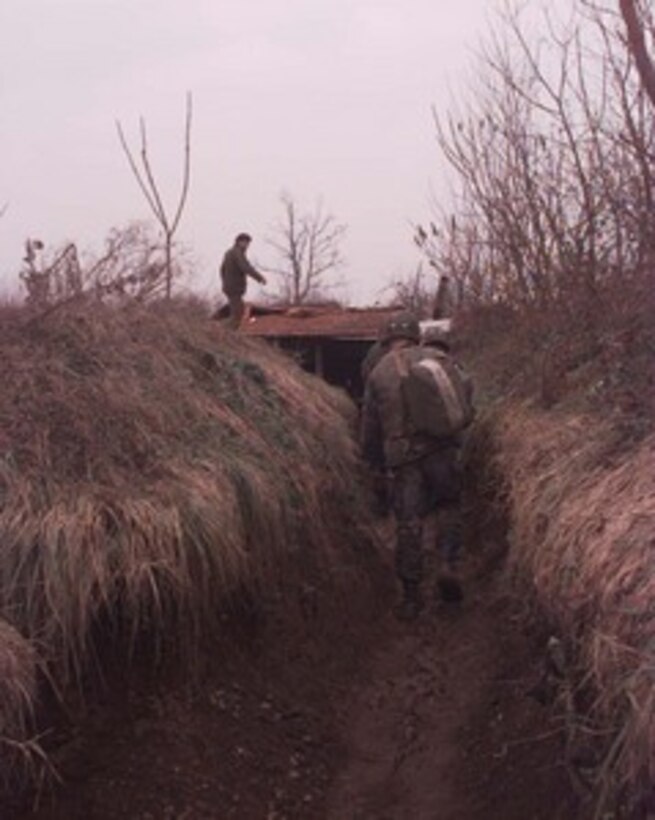 U.S. Army combat engineers move toward a Bosnian Serb bunker along the Zone of Separation in Bosnia and Herzegovina on Jan. 14, 1996. The U.S. soldiers are part of the NATO Implementation Force (IFOR) and are inspecting the bunkers and trenches along the Zone of Separation for prohibited weapons and munitions. The engineers are from the 16th Engineer Battalion, 130th Brigade, of Bamberg, Germany. 