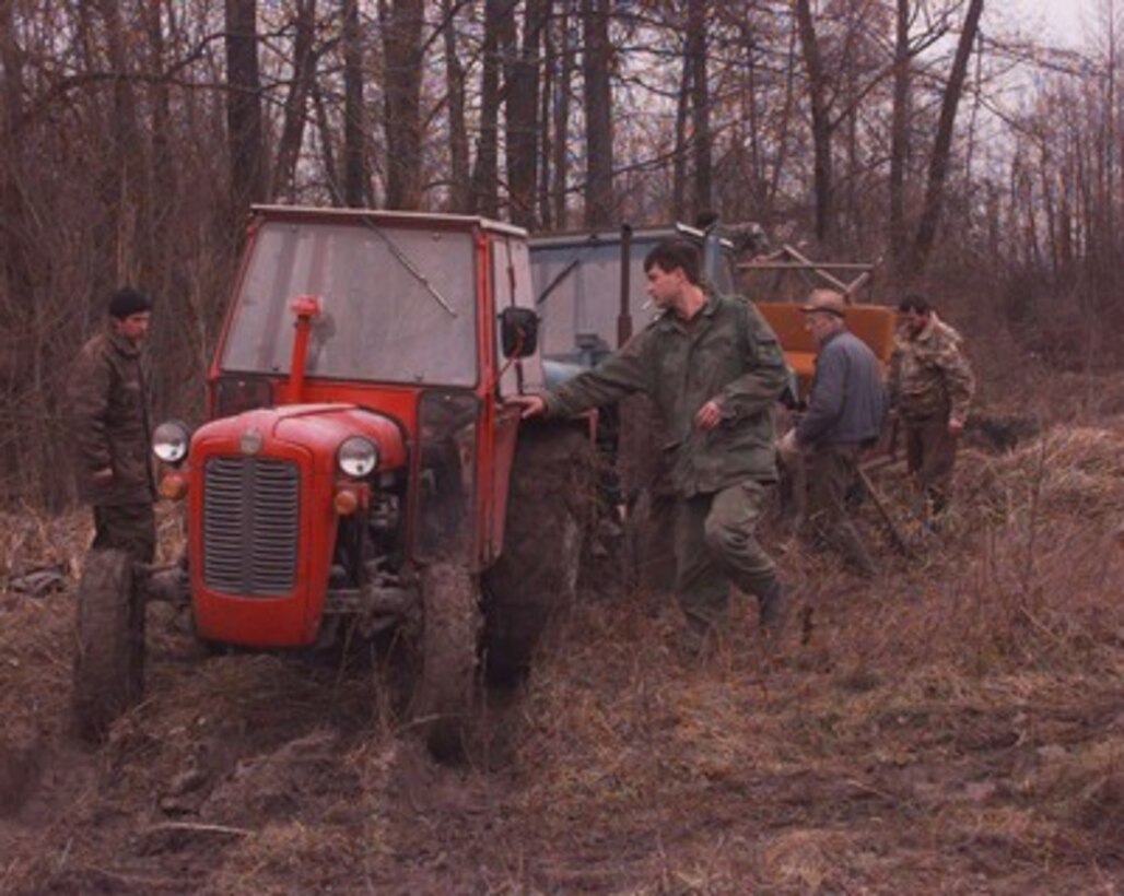 Bosnian Serb soldiers use farm tractors to haul away items removed from bunkers along the Zone of Separation in Bosnia and Herzegovina on Jan. 14, 1996. U.S. soldiers, as part of the NATO Implementation Force (IFOR), are inspecting the bunkers and trenches along the Zone of Separation for prohibited weapons and munitions. 