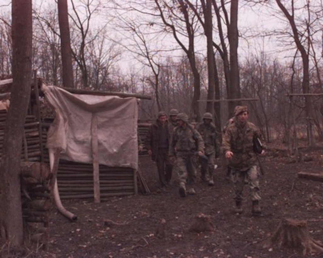 U.S. Army combat engineers follow Bosnian Serb Army Capt. Radovan Zoranovic as they inspect a Bosnian Serb bunker along the Zone of Separation in Bosnia and Herzegovina on Jan. 14, 1996. The U.S. soldiers are part of the NATO Implementation Force (IFOR) and are inspecting the bunkers and trenches along the Zone of Separation for prohibited weapons and munitions. The engineers are from the 16th Engineer Battalion, 130th Brigade, of Bamberg, Germany. Zoranovic is the commander of the 3rd Battalion, 2nd Brigade. 