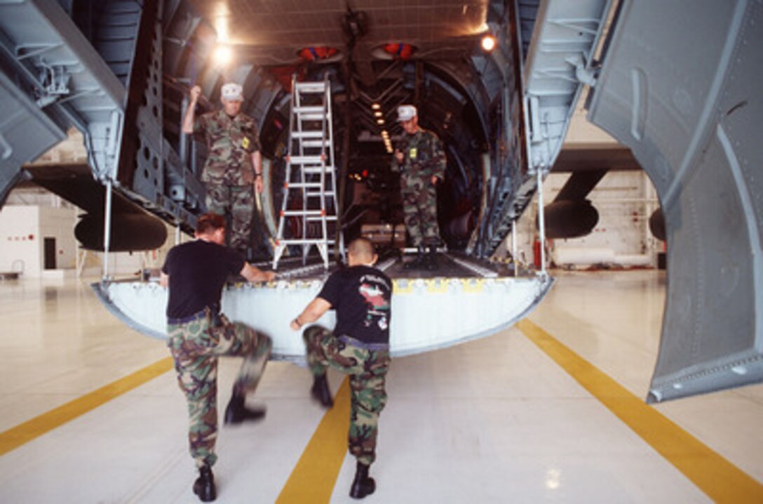 The Joint Airdrop Inspection team from the 136th Airlift Wing climbs into the aircraft as judges start the stop watches at Airlift Rodeo '96 on June 24, 1996. The team has ten minutes to find 11 malfunctions in the heavy equipment load and 6 minutes to find a total of 12 malfunctions in the bundle container delivery system. Airlift Rodeo '96 is the United States Transportation Command's tanker/airlift competition which tests the flight and ground skills of aircrews as well as the related skills of combat control, security police, aerial port, aeromedical evacuation, and maintenance team members. Crews from the U.S. and nine other countries are participating in the competition held this year at McChord Air Force Base, Wash. The 136th is based at Hensley Field, Texas. 