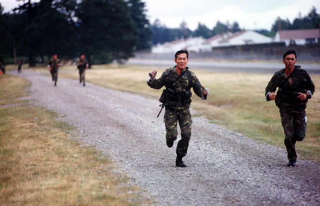 Singapore Combat Control team members encourage each other while running the biathlon competition at Airlift Rodeo '96 on June 24, 1996. Airlift Rodeo '96 is the United States Transportation Command's tanker/airlift competition which tests the flight and ground skills of aircrews as well as the related skills of combat control, security police, aerial port, aeromedical evacuation, and maintenance team members. Crews from the U.S. and nine other countries are participating in the competition held this year at McChord Air Force Base, Wash. 