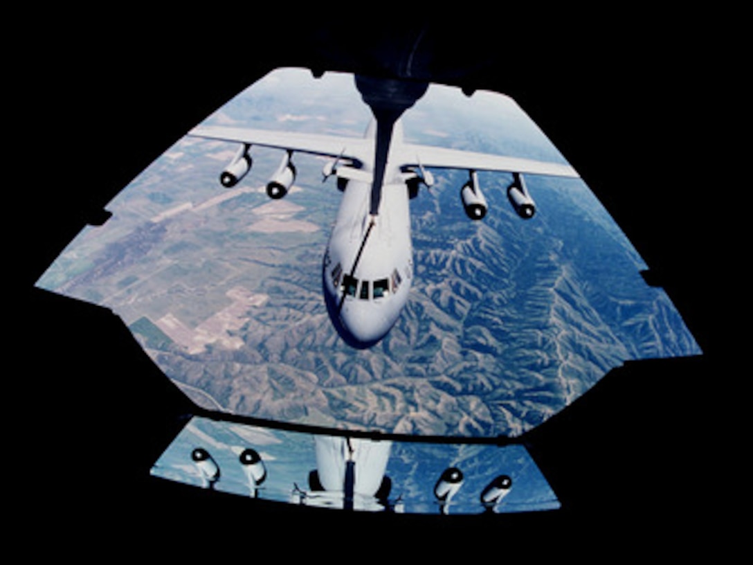 A C-141 Starlifter is visible through the KC-10 Extender boom operator ...