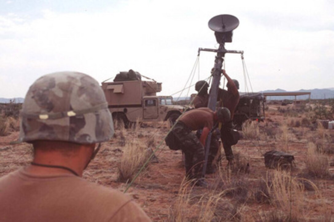 Members of Bravo Company, 16th Signal Battalion raise a communications dish on a telephone pole at the base camp on MacGregor Reservation, N.M., on June 6, 1996, during exercise Roving Sands '96. The communications dish will be used to send super high frequency signals to units taking part in Roving Sands '96 which is the world's largest joint, tactical air defense exercise involving service men and women from the U.S., Germany, the Netherlands and Canada. The exercise allows multinational forces to practice tactics, techniques and procedures improving their defense capabilities. The 16th Signal Battalion is deployed for the exercise from Fort Hood, Texas. 