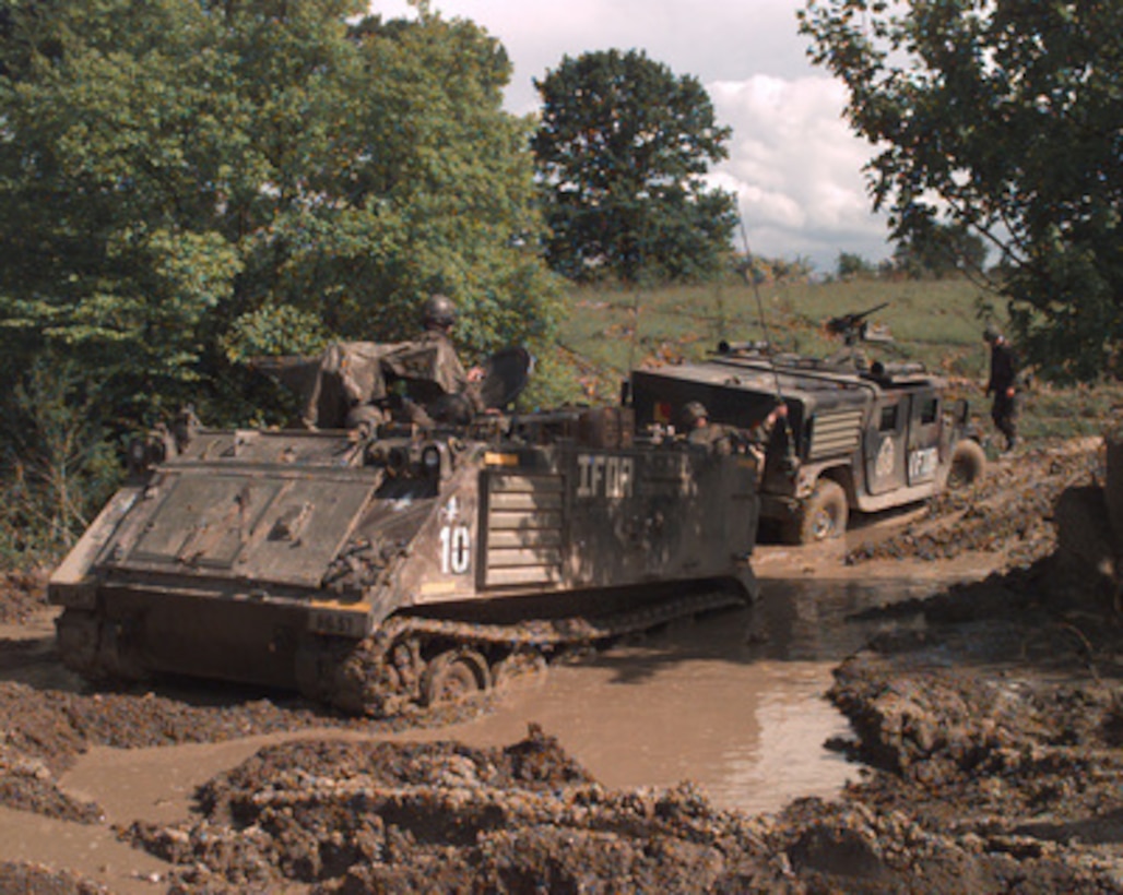 A U.S. Army M-113 Armor Personnel Carrier prepares to pull an armored Humvee out of the mud in Bosnia and Herzegovina on May 10, 1996, during Operation Joint Endeavor. The spring-time mud has presented a challenge to the soldiers and their equipment deployed to Bosnia and Herzegovina as part of the NATO Implementation Force (IFOR). 