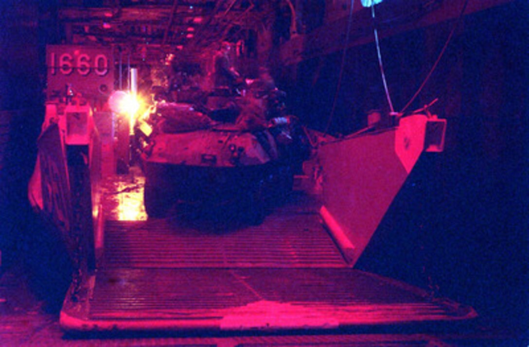 A U.S. Marine Corps Light Armored Vehicle backs onto a U.S. Navy landing craft in preparation for amphibious operations from the well deck of the USS Nassau (LHA 4) on May 7, 1996, during Combined Joint Task Force Exercise '96. The red lights are used at night to preserve the night vision of the Marines and the boat crews. More than 53,000 military service members from the United States and the United Kingdom are participating in Combined Joint Task Force Exercise '96 on military installations in the Southeastern United States and in waters along the Eastern seaboard. 