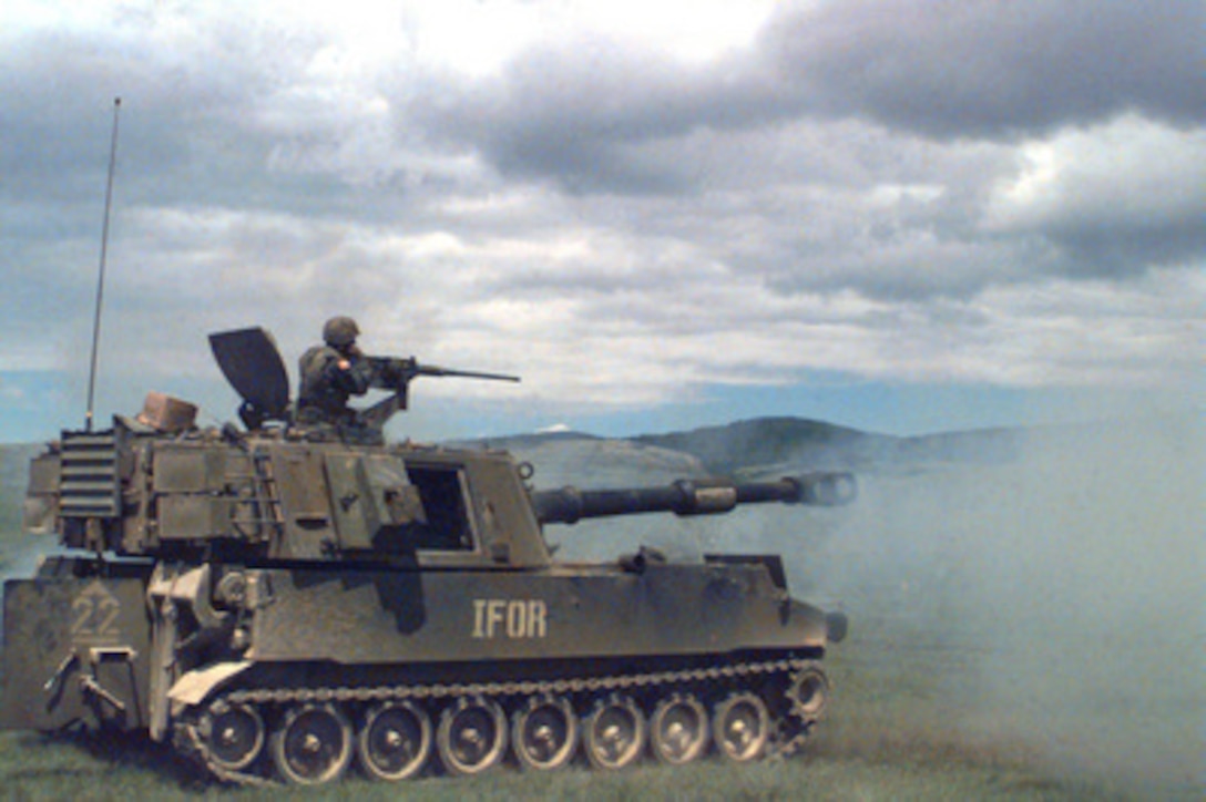 Sgt. Henry Drake looks to see where the rounds fired from his M-109A2, 155mm, Self Propelled Howitzer land during a live fire exercise near Glamoc, Bosnia and Herzegovina on May 23, 1996. Drake and his howitzer are deployed to Bosnia and Herzegovina as part of the NATO Implementation Force (IFOR) under Operation Joint Endeavor. Drake is attached to the 4th Battalion, 29th Field Artillery. 