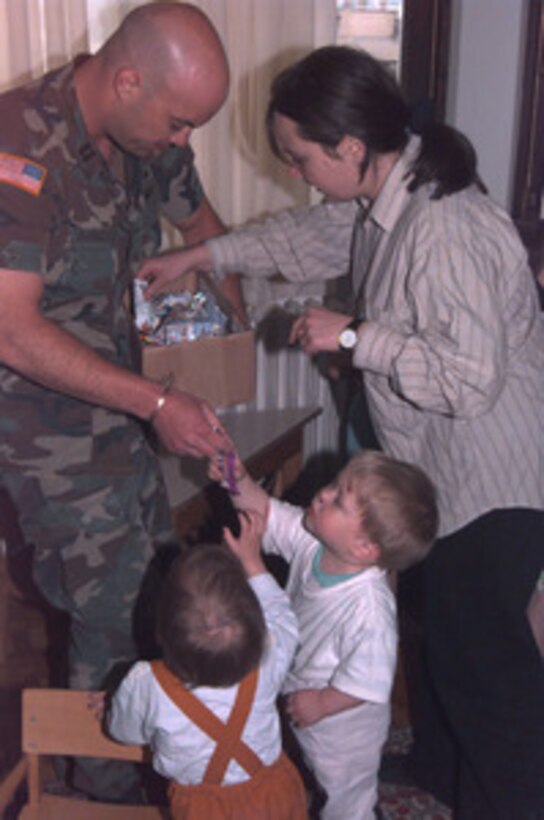 U.S. Army Capt. David Vanbuskirk passes out candy to orphans at Bjelave Orphanage in Sarajevo, Bosnia and Herzegovina, on May 23, 1996. Vanbuskirk, an Army interpreter with the Combined Joint Civil Military Co-Operation, received candy, food and clothing from well-wishers in the U.S. Vanbuskirk divided the large donation of goods between Muslim and Serbian orphanages. 