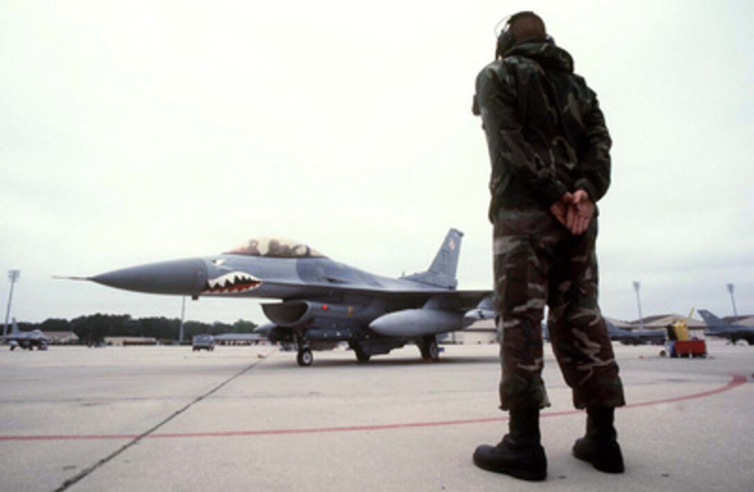 U.S. Air Force Senior Airman Jon Basar waits to give the signal to Capt. Brett McCann to launch his F-16 Fighting Falcon from Pope Air Force Base, N.C., on May 7, 1996, for a simulated combat mission during Combined Joint Task Force Exercise '96. More than 53,000 military service members from the United States and the United Kingdom are participating in Combined Joint Task Force Exercise '96 on military installations in the Southeastern United States and in waters along the Eastern seaboard. Basar and McCann are attached the 74th Fighter Squadron at Pope. 