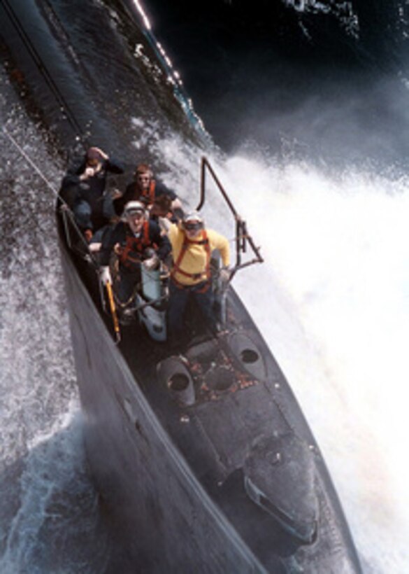 Crew members of the Los Angeles-class submarine USS Scranton (SSN 756) stand by on the sail of the submarine for a supply delivery from a SH-60F Sea Hawk helicopter while surfaced in the Arabian Sea on May 9, 1996. The Sea Hawk was flying from the flight deck of the aircraft carrier USS George Washington (CVN 73). The George Washington and its battle group were operating in the Arabian Gulf where they conducted air patrols in support of Operation Southern Watch. Southern Watch is the U.S. and coalition enforcement of the no-fly-zone over Southern Iraq. 