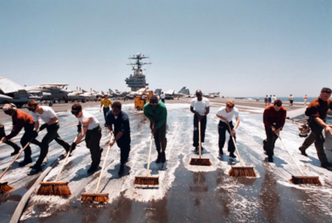 Air Department crew members on board the aircraft carrier USS George Washington (CVN 73) participate in a flight deck Scrub-Ex under the scorching sun of the Arabian Sea on May 9, 1996. The George Washington and its battle group were operating in the Arabian Gulf where they conducted air patrols in support of Operation Southern Watch. Southern Watch is the U.S. and coalition enforcement of the no-fly-zone over Southern Iraq. 