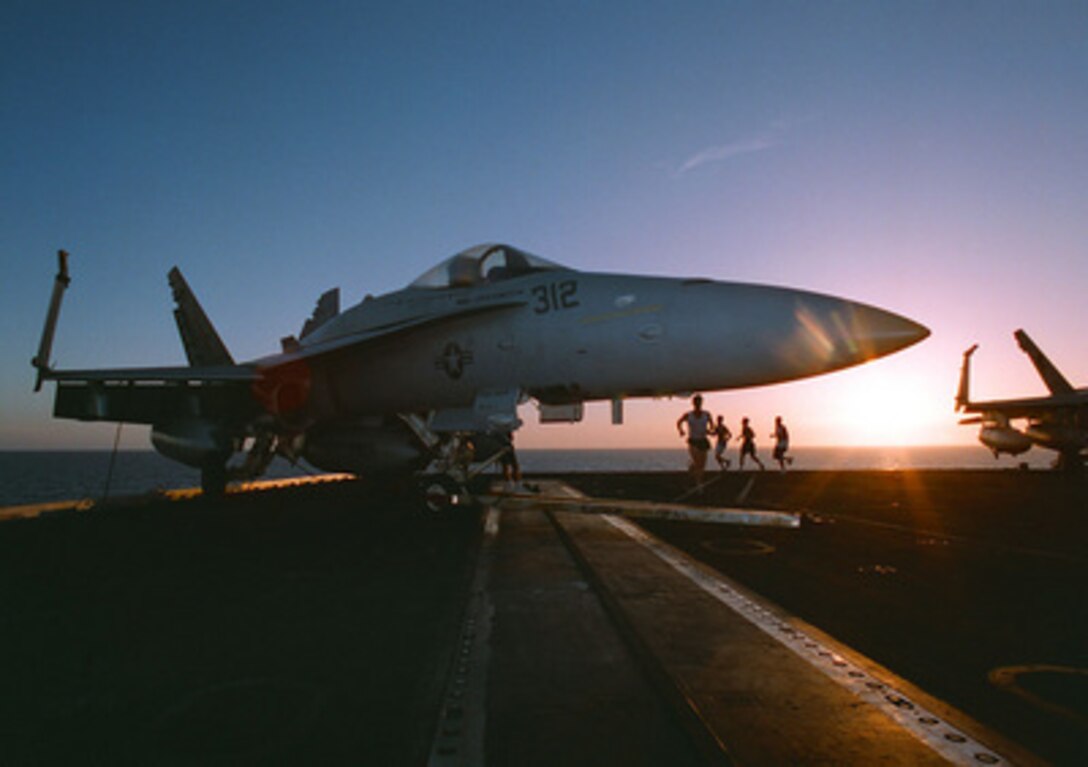 Silhouetted against the evening sun of the Arabian Sea, joggers take advantage of a no-fly day on the aircraft carrier USS George Washington (CVN 73) to run on the flight deck on May 9, 1996. The George Washington and its battle group were operating in the Arabian Gulf where they conducted air patrols in support of Operation Southern Watch. Southern Watch is the U.S. and coalition enforcement of the no-fly-zone over Southern Iraq. 