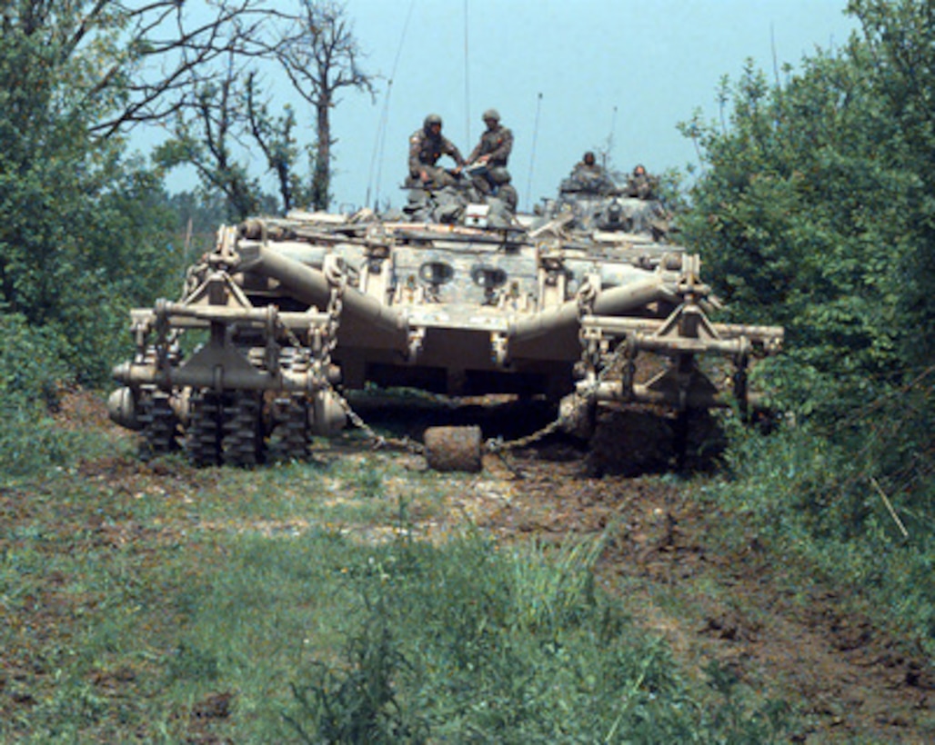 A remotely controlled Panther armored mine clearing vehicle leads a column of armored vehicles down a road near McGovern Base, in Bosnia and Herzegovina on May 16, 1996, during Operation Joint Endeavor. The Panther, based on a modified M-60 tank hull, uses metal rollers to set off contact or magnetic mines. The Panther is being operated by the 23rd Engineer Battalion, 1st Brigade, 1st Armored Division. 