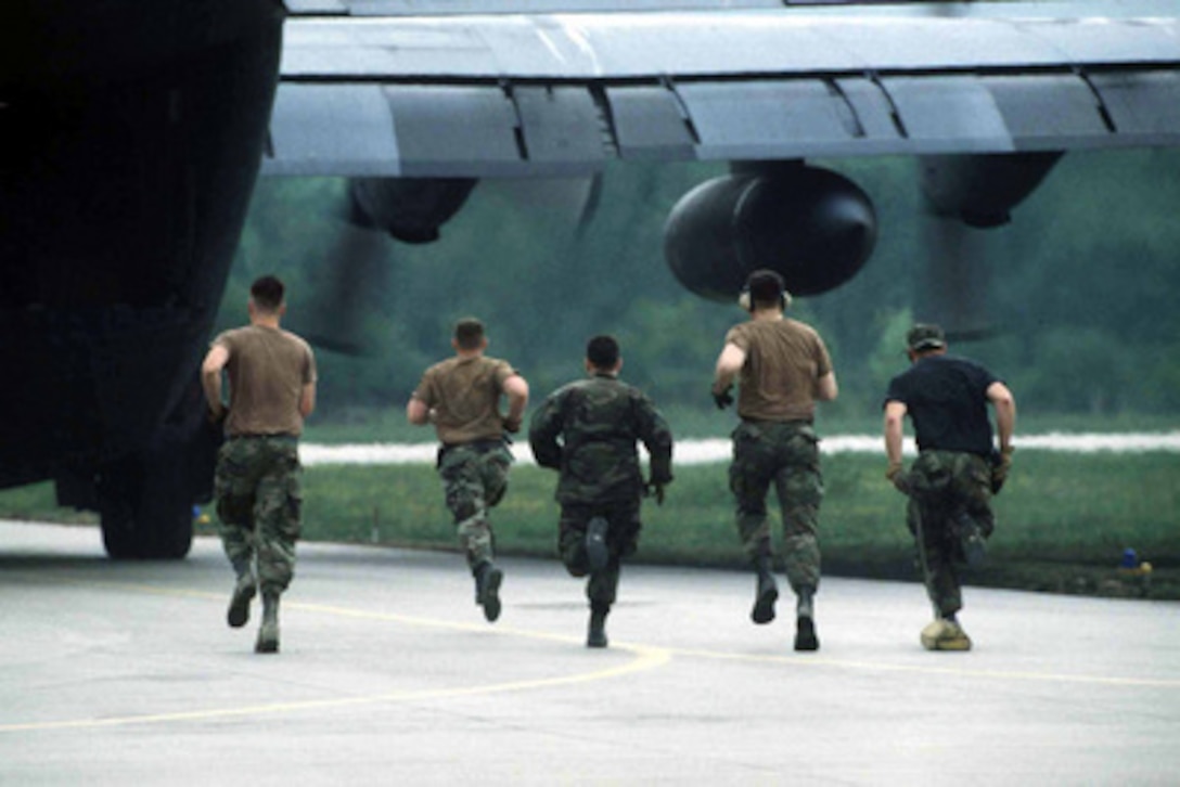 U.S. Air Force airmen from the 62nd Aerial Port Squadron run out to meet a C-130 Hercules after it stops on the ramp at Tuzla, Bosnia and Herzegovina on May 12, 1996. The aircraft will be only on the ground for a short period of time as the well-practiced members of the 62nd can unload it in under 20 minutes with engines running. The C-130's, based at Ramstein Air Base, Germany, are bringing equipment and supplies from all over the world to Bosnia and Herzegovina where it will be used by the NATO Implementation Force (IFOR). The 62nd Aerial Port Squadron airmen are deployed from McChord Air Force Base, Wash. 