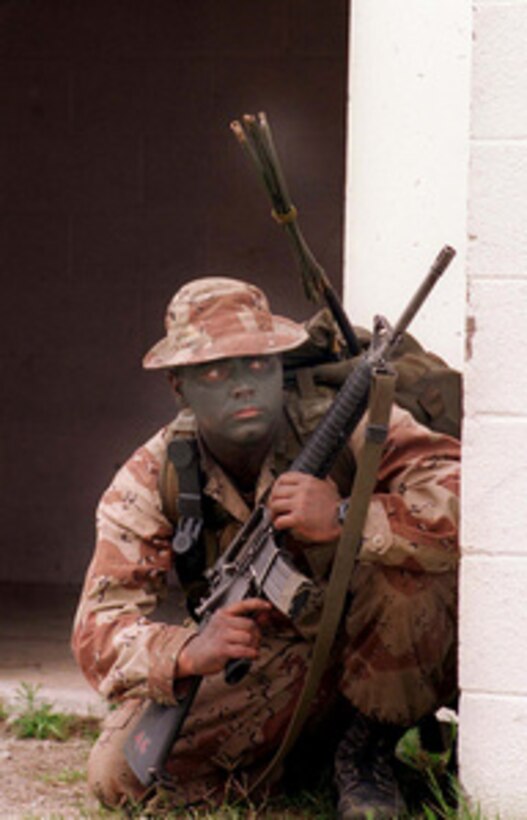 A U.S. Marine from Fox Company, acting as opposing forces, checks around the corner of a building for intruders during an assault by British Gurkhas on the Military Operations on Urbanized Terrain facility at Camp Lejeune, N.C., during Combined Joint Task Force Exercise '96 on May 13, 1996. More than 53,000 military service members from the United States and the United Kingdom are participating in Combined Joint Task Force Exercise '96 on military installations in the Southeastern United States and in waters along the Eastern seaboard. Fox Company Marines are attached to 2nd Battalion, 6th Marines, 2nd Marine Division. 
