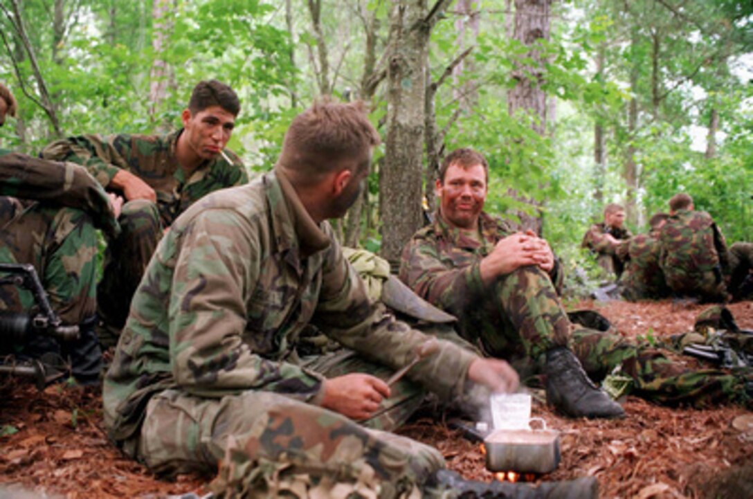 U.S. Marine Cpl. Patrick Conell (left) and British Royal Marine Cpl. Wayne Roberts have a conversation while heating up English rolled oats, from a British field ration as they break for chow at Camp Lejeune, N.C., during Combined Joint Task Force Exercise '96 on May 16, 1996. More than 53,000 military service members from the United States and the United Kingdom are participating in Combined Joint Task Force Exercise '96 on military installations in the Southeastern United States and in waters along the Eastern seaboard. Conell is from Lacrosse, Wis. 