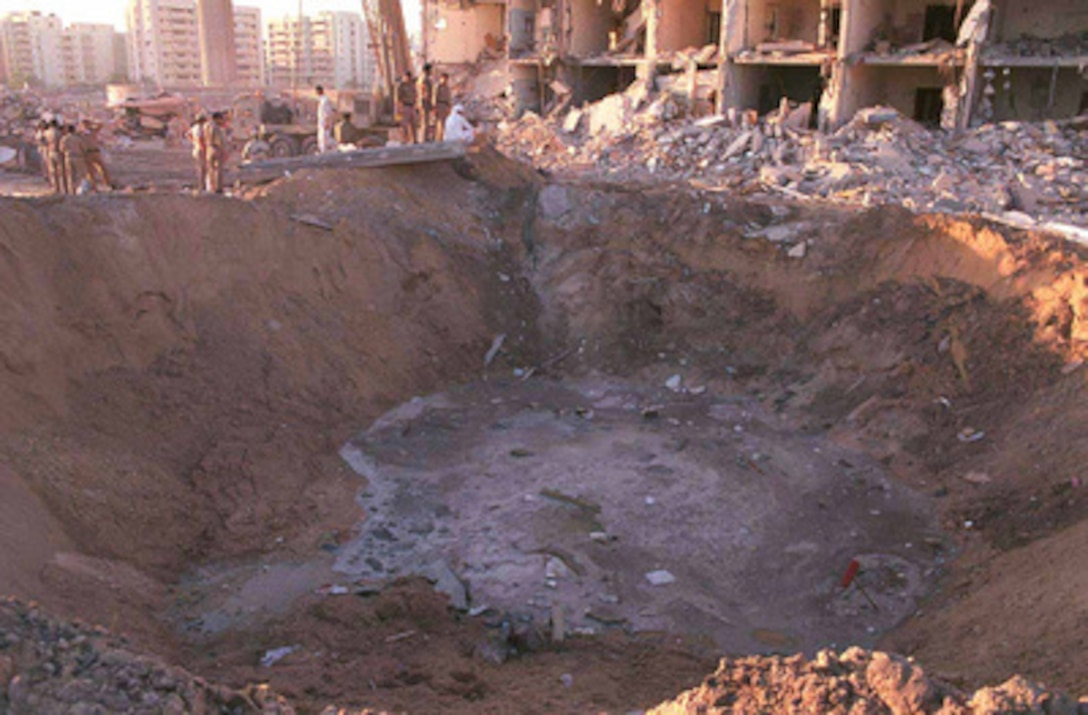 U.S. and Saudi military personnel peer into the crater caused by the explosion of a fuel truck outside the northern fence of Khobar Towers on King Abdul Aziz Air Base near Dhahran, Saudi Arabia, at 2:55 p.m. EDT, Tuesday, June 25, 1996. Several buildings were damaged and there were numerous U.S. casualties. The latest information from Dhahran indicates that 19 people are dead and 64 people are hospitalized. Additionally, over 200 have been treated for injuries and released. The facility houses U.S. service members and serves as the headquarters for the U.S. Air Force's 4404th Wing (Provisional), Southwest Asia. 