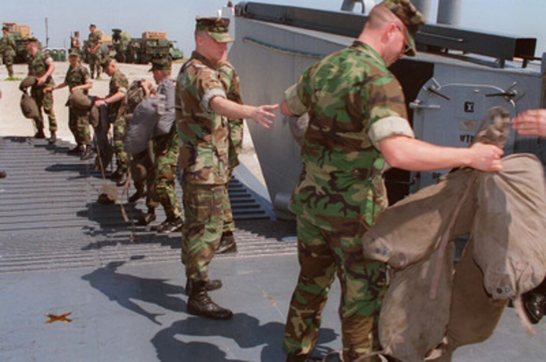 U.S. Marines from Headquarters Company, 8th Marine Regiment, form a chain to move life jackets to their fellow Marines awaiting loading on a U.S. Navy Landing Craft Utility at Radio Island near Morehead City, N.C., on May 4, 1996, for Combined Joint Task Exercise 96. More than 53,000 military service members from the United States and the United Kingdom are participating in Combined Joint Task Force Exercise 96 on military installations in the Southeastern United States and in waters along the Eastern seaboard. The landing craft will transport Marines from the 2nd Marine Division to the USS Nassau (LHA 4) for the exercise. 
