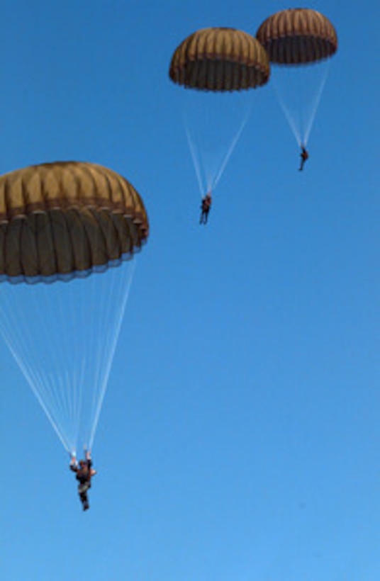 Three parachutists come in for a landing as Special Forces from the U.S. and United Kingdom take part in High Altitude Low Opening and static line parachute jumps from U.S. and U.K. C-130 Hercules aircraft on May 2, 1996, during Combined Joint Task Force Exercise 96. British Special Air Service, U.S. Navy SEAL's, U.S. Army Special Forces and U.S. Air Force Combat Controllers and Pararescue Jumpers took part in the jumps. More than 53,000 military service members from the United States and the United Kingdom are participating in Combined Joint Task Force Exercise 96 on military installations in the Southeastern United States and in waters along the Eastern seaboard. 