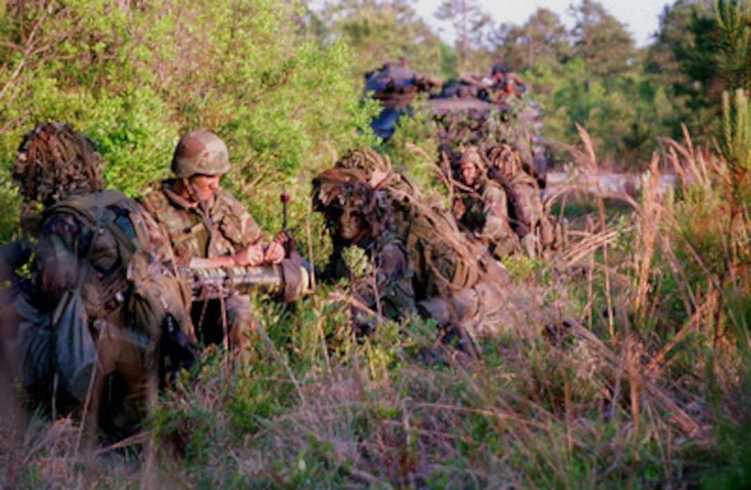 U.S. Marines from Kilo Company, 3rd Battalion, 8th Marine Regiment, 2d Marine Division, begin to form a perimeter after unloading from Amphibious Assault Vehicles in Landing Zone Hawk, Camp Lejeune, N.C., on May 10, 1996. The Marines are part of more than 53,000 military service members from the United States and the United Kingdom are participating in Combined Joint Task Force Exercise 96 on military installations in the Southeastern United States and in waters along the Eastern seaboard. 