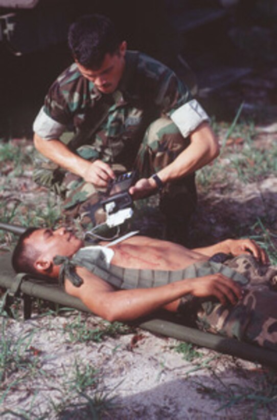Petty Officer 3rd Class Robert Hill, of the 3rd Medical Battalion, Camp Hansen, Okinawa, examines a Royal Thai Marine to determine his medical condition during a mass casualty drill at Songkhla, Thailand, on May 9, 1996, as part of Exercise Cobra Gold '96. Cobra Gold '96 is the latest in a continuing series of U.S./Thai military exercises designed to ensure regional peace and strengthen the ability of the Royal Thai Armed Forces to defend Thailand. Hospital Corpsman Hansen is one of approximately 9,000 U.S. and 10,000 Thai personnel are participating in the exercise. 