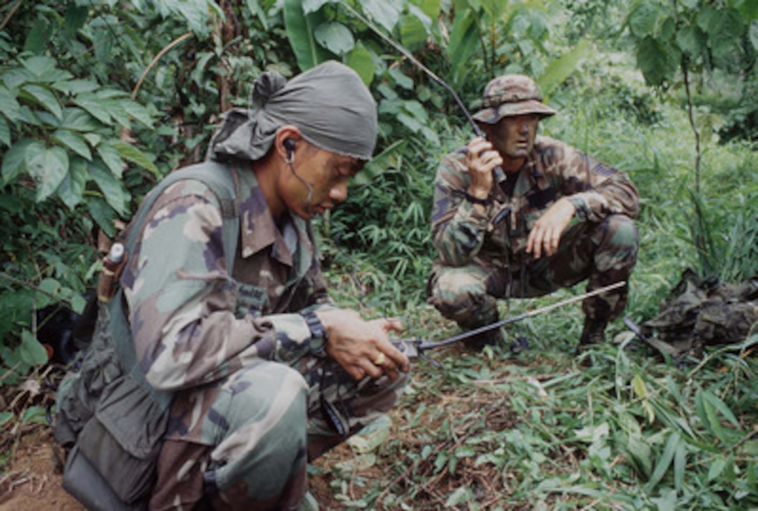 Royal Thai Air Force Sgt. Sutthiphan Jankeeree (left) and U.S. Air Force Master Sgt. Joe Sitterly (right) communicate on a PRC-90 HF Radio as part of Search and Rescue training at Khao Na Ting, Thailand, on May 13, 1996, during Exercise Cobra Gold '96. Cobra Gold '96 is the latest in a continuing series of U.S./Thai military exercises designed to ensure regional peace and strengthen the ability of the Royal Thai Armed Forces to defend Thailand. Approximately 9,000 U.S. and 10,000 Thai personnel are participating in the exercise. Jankeeree is attached to the Rescue Coordination Center, Bangkok. Sitterly is from the Pacific Rescue Coordination Center, Hickam Air Force Base, Hawaii. 