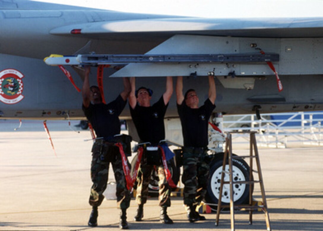 A ground crew loads an AIM-9 Sidewinder missile onto a F-15 Eagle at Tyndall Air Force Base, Fla., on Oct. 24, 1996, during William Tell '96. William Tell is an annual competition designed to challenge the air-to-air capabilities of combat air forces and have their crews perform under simulated combat conditions. The crew and aircraft are from the 33rd Fighter Wing, Eglin Air Force Base, Fla. 