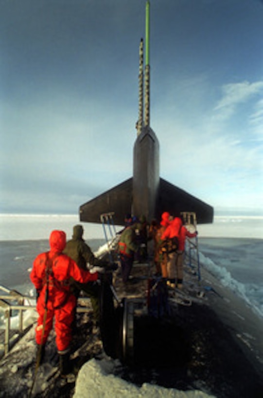 Crew members of the attack submarine USS Pogy (SSN 647) assemble a topside deck enclosure to provide protection from the Arctic elements after the sub surfaced through a 6 inch thick layer of Arctic ice flow. The submarine is on a 45-day research mission to the North Pole. Seven scientists and technical advisors are conducting experiments and collecting samples for studies in water mass properties, geophysics, ice mechanics and pollution detection in the Arctic Ocean. The research voyage is the second of five planned deployments through the year 2000. 