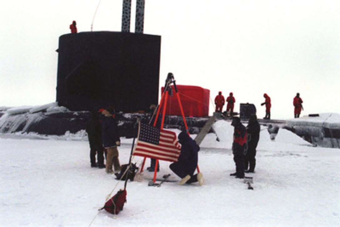 Scientists and crew members assigned to the attack submarine USS Pogy (SSN 647) conduct experiments on and under the Arctic ice flow. The submarine is on a 45-day research mission to the North Pole. Seven scientists and technical advisors are conducting experiments and collecting samples for studies in water mass properties, geophysics, ice mechanics and pollution detection in the Arctic Ocean. The red tent temporary erected on the hull of the Pogy provides protection from the Arctic elements and a space to conduct more delicate procedures. The research voyage is the second of five planned deployments through the year 2000. 