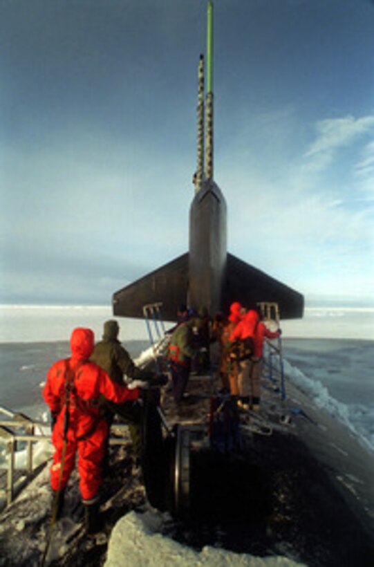 Crew members of the attack submarine USS Pogy (SSN 647) assemble a topside deck enclosure to provide protection from the Arctic elements after the sub surfaced through a 6 inch thick layer of Arctic ice flow. The submarine is on a 45-day research mission to the North Pole. Seven scientists and technical advisors are conducting experiments and collecting samples for studies in water mass properties, geophysics, ice mechanics and pollution detection in the Arctic Ocean. The research voyage is the second of five planned deployments through the year 2000. 