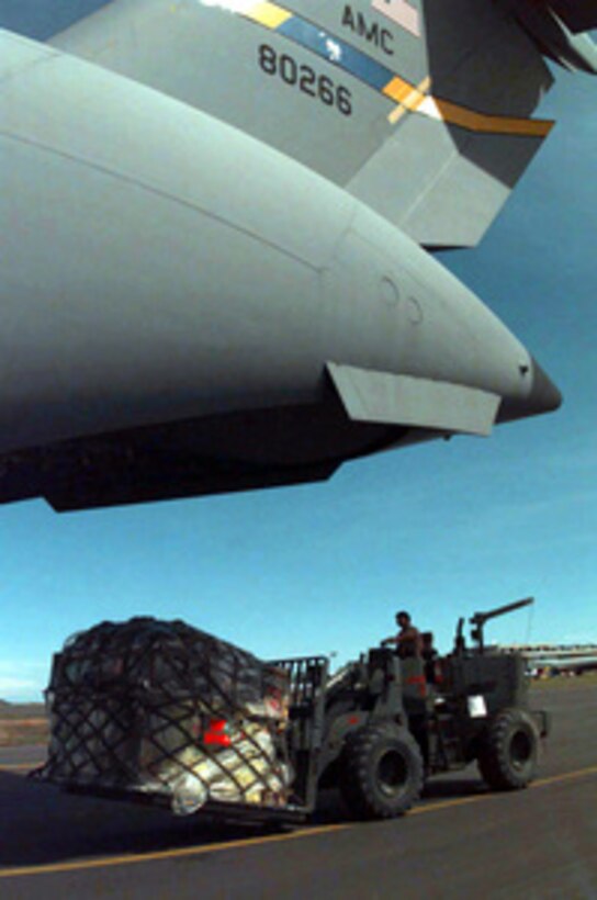 U.S. Air Force Staff Sgt. Johnny Quindara operates a fork lift to unload supplies and equipment from a C-17 Globemaster III at Entebbe International Airport, Uganda, on Nov. 26, 1996. More than 200 airmen have set up operations at Entebbe, consisting primarily of a Tanker Airlift Control Element, or TALCE, which is responsible for loading cargo and servicing the aircraft. Entebbe could become a cargo hub for the possible multinational, military humanitarian operation in Central Africa. Larger Air Force cargo planes, such as the C-5 Galaxy and C-17 Globemaster III, can land here and unload their cargo, which would then be transferred to the C-130 Hercules for delivery throughout the theater. Nearly 400 military logistics personnel are at airports in Mombasa, Kenya, in Entebbe, Uganda, and in Kigali, Rwanda. Quindara is deployed from the 615th Aerial Port Squadron, Travis Air Force Base Calif. The C-17 is from the 14th Airlift Squadron, Charleston Air Force Base, S.C. 
