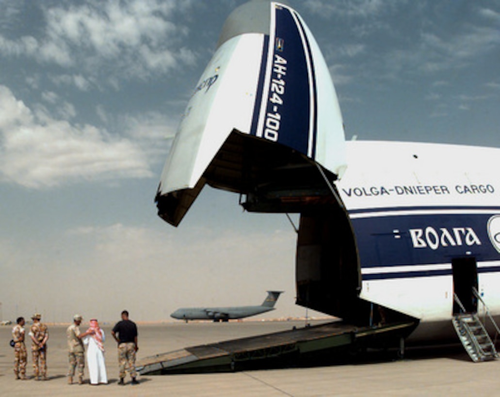 U.S., British, and Saudi Arabian personnel discuss the off-load of a Russian AN-124 aircraft on the tarmac at Prince Sultan Air Base, Al Kharj, Saudi Arabia, on Aug. 26, 1996. British personnel are using the charter aircraft to move in equipment to support the Royal Air Force Tornadoes fighter/attack aircraft conducting Operation Southern Watch to Al Kharj. Personnel, aircraft, and equipment are being moved from bases in Dhahran and Riyadh to the remote desert air base to reduce their vulnerability to terrorist attack. Southern Watch is the coalition enforcement of the no-fly-zone over Southern Iraq. 