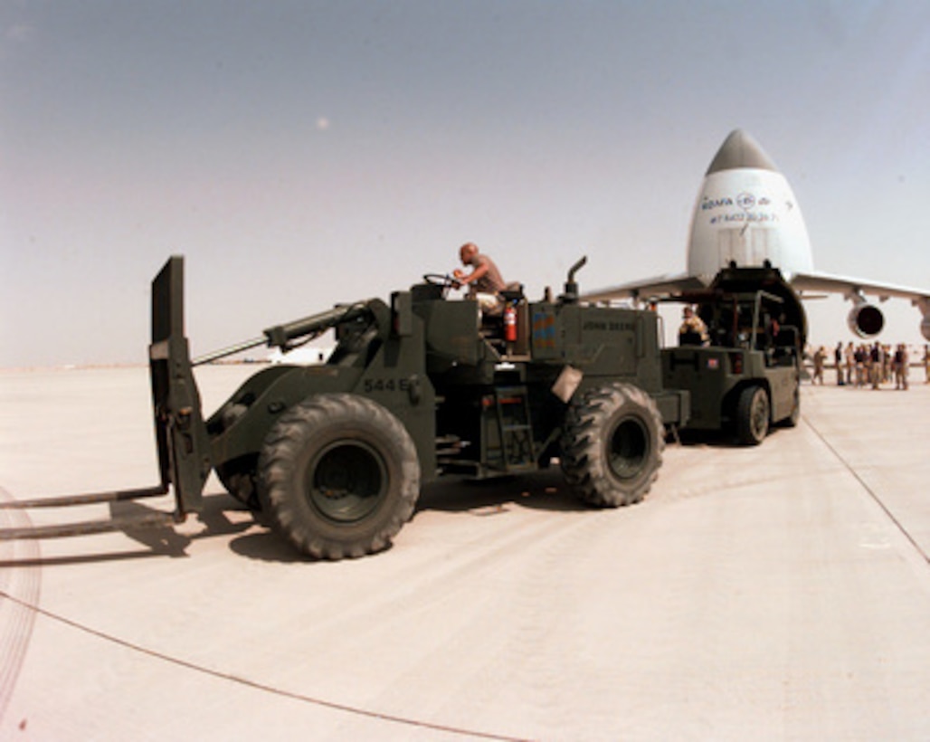 U.S. Air Force Airman Travis Crane, of the 615th Aerial Port Squadron, uses his forklift to tow a British fork lift truck off a Russian AN-124 transport aircraft at Prince Sultan Air Base, Al Kharj, Saudi Arabia, on Aug. 26, 1996. British personnel are arriving to support the move of Royal Air Force Tornadoes fighter/attack aircraft conducting Operation Southern Watch to Al Kharj. Personnel, aircraft, and equipment are being moved from bases in Dhahran and Riyadh to the remote desert air base to reduce their vulnerability to terrorist attack. Southern Watch is the coalition enforcement of the no-fly-zone over Southern Iraq. Crane is deployed from Travis Air Force Base, Calif. 
