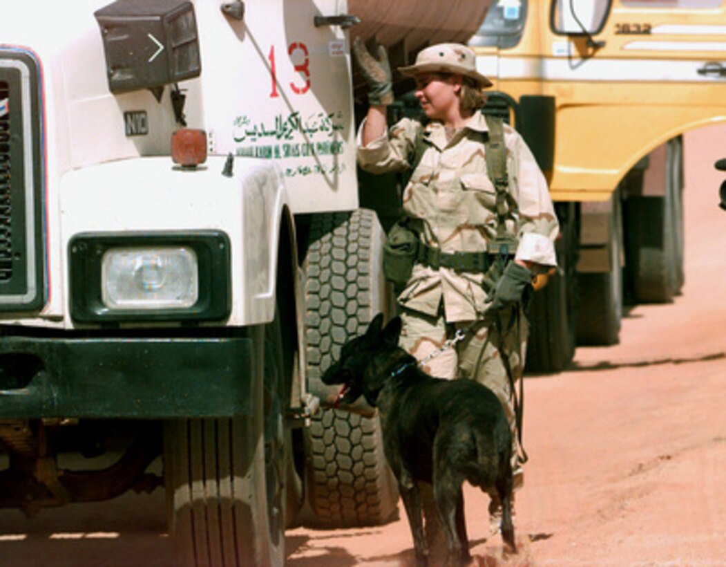 Senior Airman Tammy Kirksey, an Explosives Detector Dog Handler, and her dog Jacky search a contracted vehicle at the Echo 6 Entry Control Point Gate, at Prince Sultan Air Base, Al Kharj, Saudi Arabia, on Sept. 7, 1996. Personnel, aircraft, and equipment conducting Operation Southern Watch are being moved from bases in Dhahran and Riyadh to Prince Sultan to reduce their vulnerability to terrorist attack. Kirksey and Jacky are deployed from the 2nd Security Police Squadron, Barksdale Air Force Base, La., as part of the Security Police contingent at the base providing Security Support. Southern Watch is the U.S. and coalition enforcement of the no-fly-zone over Southern Iraq. 
