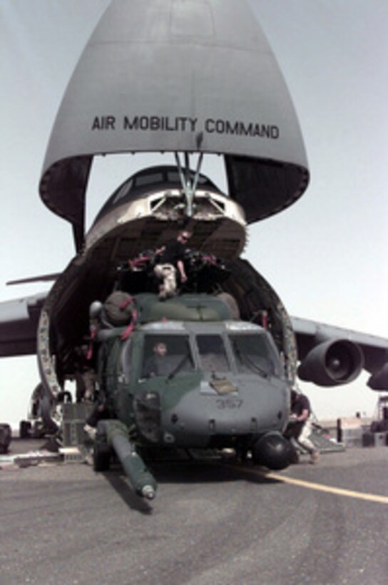A U.S. Air Force MH-60G Pave Hawk helicopter is guided out of a C-5 Galaxy at the Kuwait International Airport, on Sept. 15, 1996. The helicopter and crew members are from the 48th Rescue Squadron, Holloman Air Force Base, N.M., and are deployed to Kuwait to respond in the event any U.S. or coalition airmen are downed in the region. The Galaxy is deployed from the 436th Airlift Wing, Dover Air Force Base, Del. 